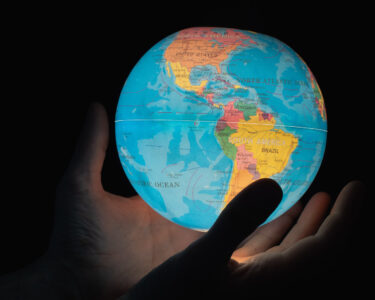 Manos-sostienen-un-mapa-mundi-con-luz-interior